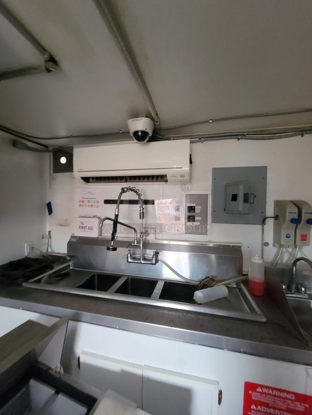 Interior of a 2020 Rock Solid 16' mobile kitchen trailer featuring a three-compartment sink, first aid kit, and Mitsubishi HVAC unit.