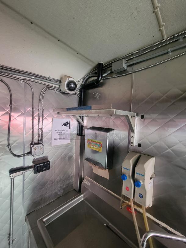 2018 Quality Cargo 16' food trailer interior, showing professional kitchen equipment, Ecolab dispensers, and compliance signage.