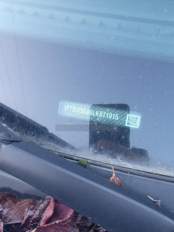 VIN plate of a 2020 Ford Transit 350 Cargo Van, visible through the windshield, showing number 1FTBW3X86LKB71915.