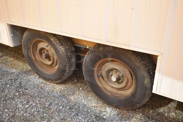 Unbranded food trailer with dual wheels, equipped with Diehard 27DC-2 battery, Eaton power box, counter, and ventilation fan.