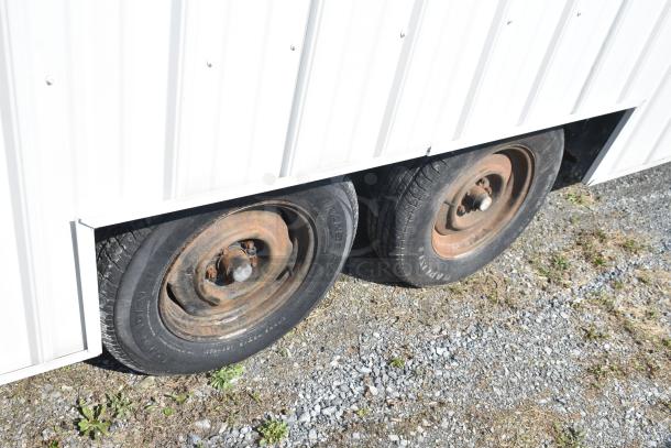Unbranded food trailer with dual wheels, featuring a Diehard 27DC-2 battery, Eaton power box, counter, and ventilation fan.