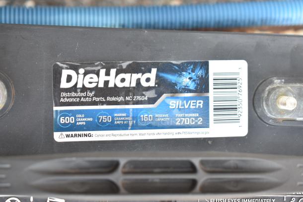 DieHard 27DC-2 battery label showing specs: 600 cold cranking amps, 750 marine cranking amps, 160 reserve capacity. Warning noted.