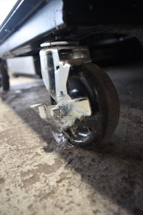 2020 True T-49-HC cooler caster detail. Sturdy metal caster on commercial cooler, showing wear.