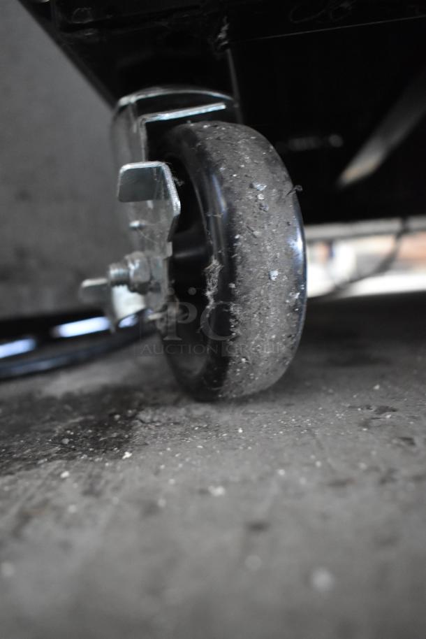 Commercial caster wheel of 2020 True T-49F-HC freezer, showing some dirt. Suitable for mobility in commercial settings.