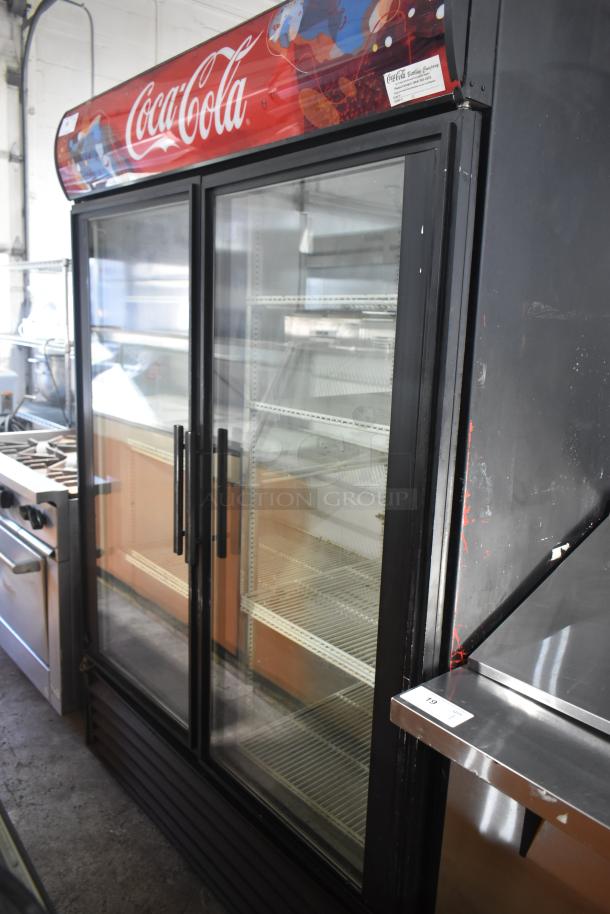True GDM-49 commercial 2-door reach-in cooler with Coca-Cola branding. Glass doors, shelving visible, 115 volts, 1 phase.