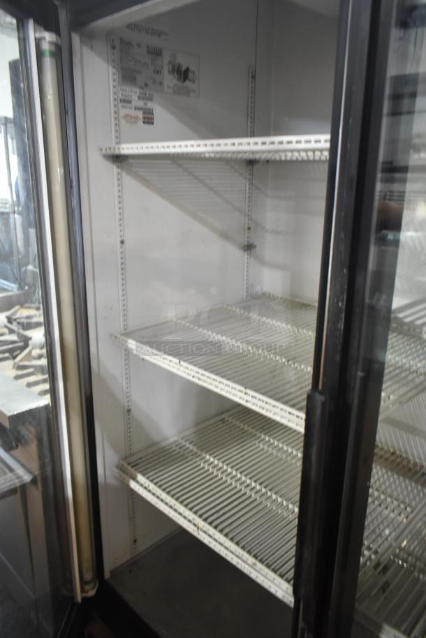 True GDM-49 commercial 2-door reach-in cooler, 115 volts, 1 phase. Interior shelving visible, in good condition.