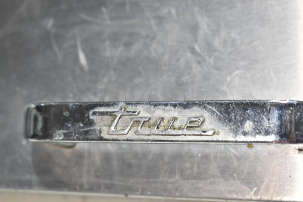2019 True TSSU-60-16D-2-HC prep table handle with brand logo visible, showing signs of wear.