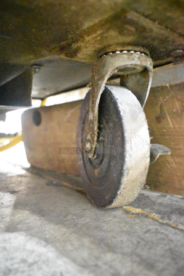 Close-up of a commercial caster wheel on the 2019 True TSSU-60-16D-2-HC Sandwich Salad Prep Table, showing wear.