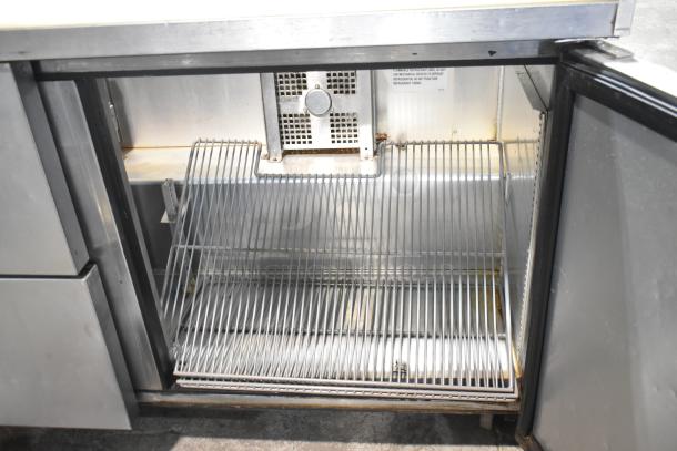 2019 True TSSU-60-16D-2-HC prep table with stainless steel interior, 2 drawers, 1 door, on casters. Visible shelf rack.