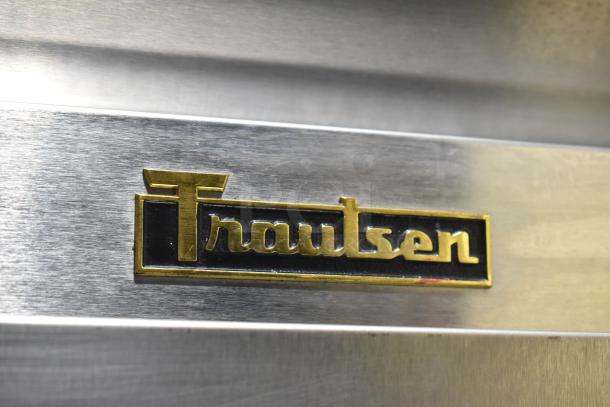Traulsen logo on stainless steel surface, model G31010 commercial 3-door reach-in freezer, 115V, 1 phase.