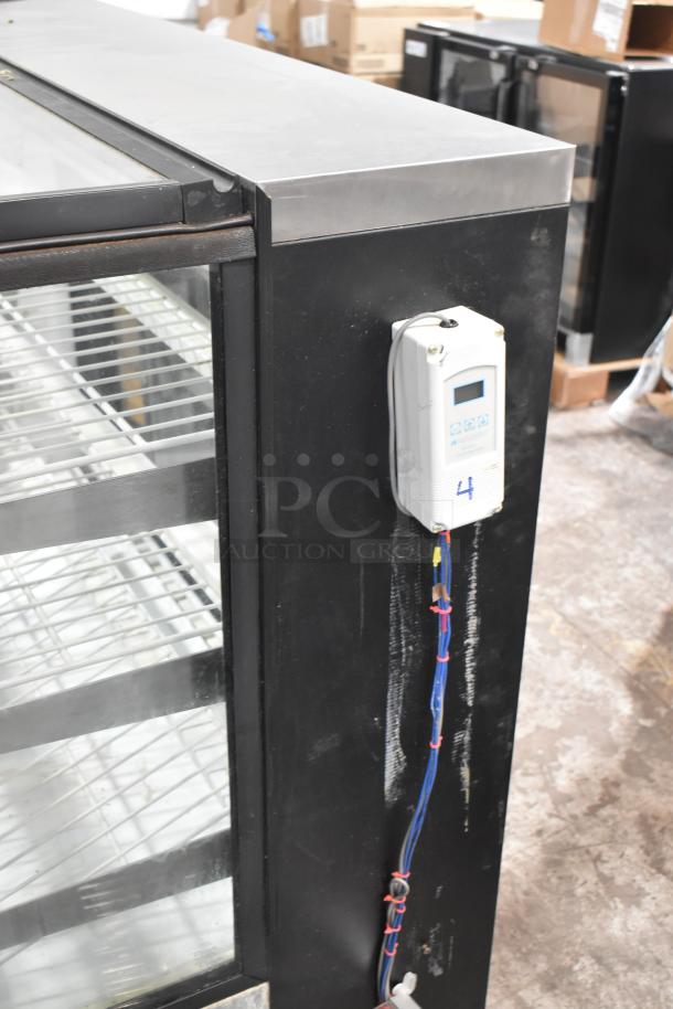 True TCGR-50 refrigerated display case, black exterior, visible wiring, shelving inside, 115 Volts, 1 Phase.