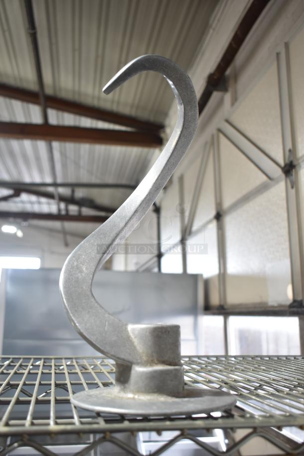 Hobart dough hook attachment on metal shelf, in good condition, made from durable metal. Ideal for commercial mixers.