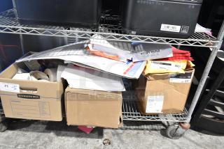 Auction lot with Pride string lights, light-up bracelets, exam table paper, and manila end tab file folders. Mixed office and decor items.