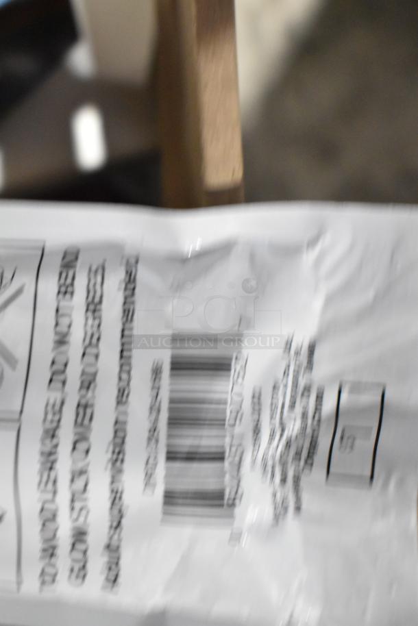 Blurred close-up of a white package with text and a barcode, possibly part of a tier lot item.