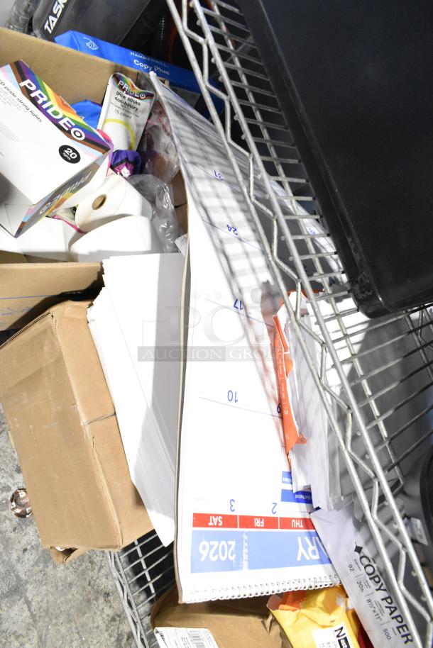 Tiered lot with Pride string lights, light-up bracelets, exam table paper, manila end tab folders, and paper supplies.