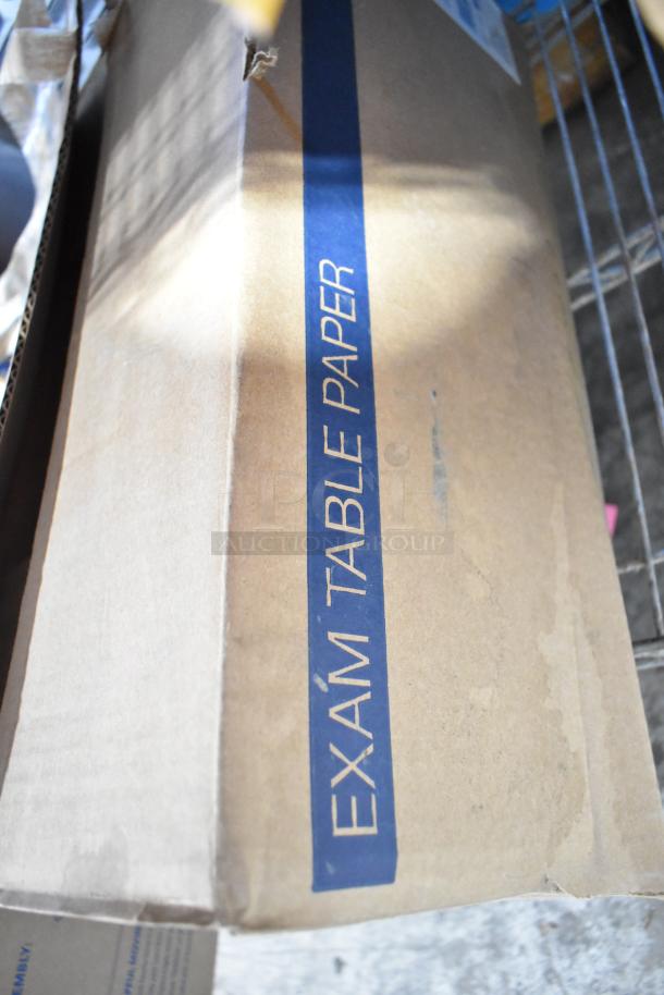 Box labeled "Exam Table Paper" from a tier lot with Pride String Lights, Light Up Bracelets, and Manila File Folders.