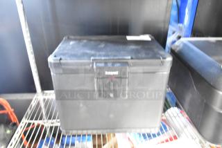 Honeywell black safe, visible brand logo, sturdy design, no key included, good condition, stored on metal shelf.