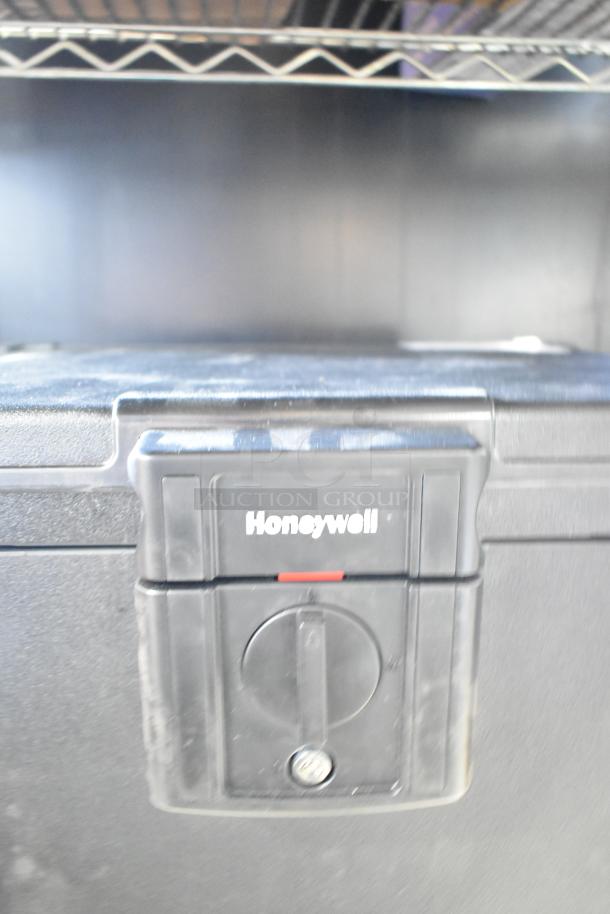 Honeywell safe without key, featuring a secure locking mechanism, good condition, some surface wear visible.