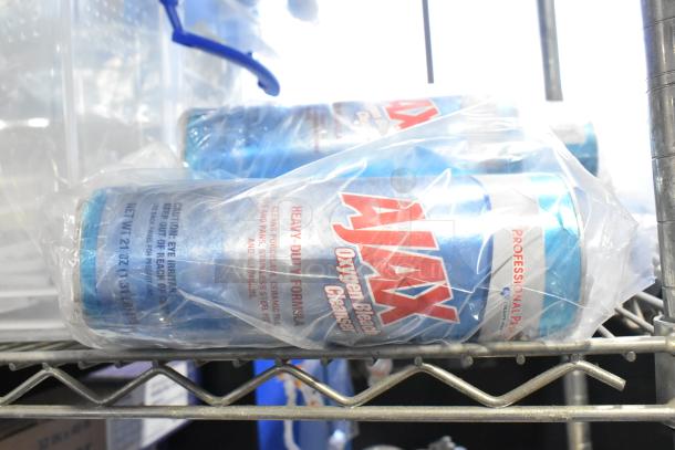 Two-tier lot with Ajax Oxygen Bleach Cleanser in packaging on metal shelf, part of cleaning supply auction.