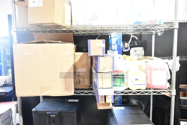 Two-tier lot with Diversey cleaners, Gojo handwash, and Ajax cleaner. Items in boxes on metal shelf.