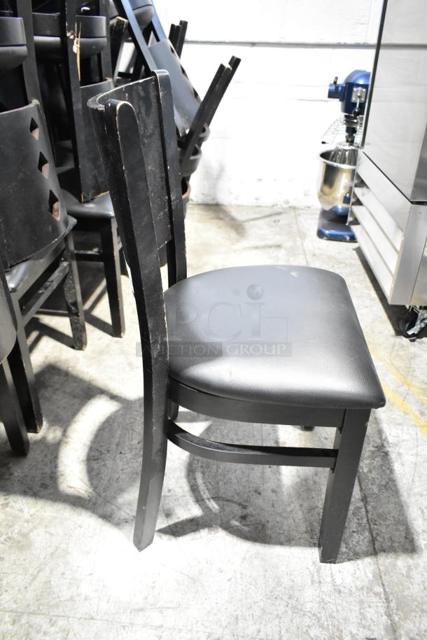 Set of 21 black dining height chairs with black seat cushions, showing wear on edges, ideal for bulk purchase.