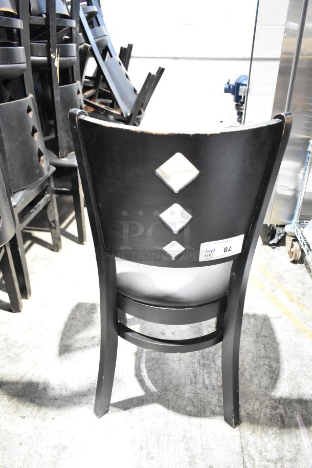 21 black dining chairs with black seat cushions, diamond pattern on backrest, average condition, auction label visible.