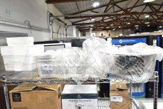 10 brand new scratch and dent items, including bowls, food containers, basting cover, and sediment trays on shelves.