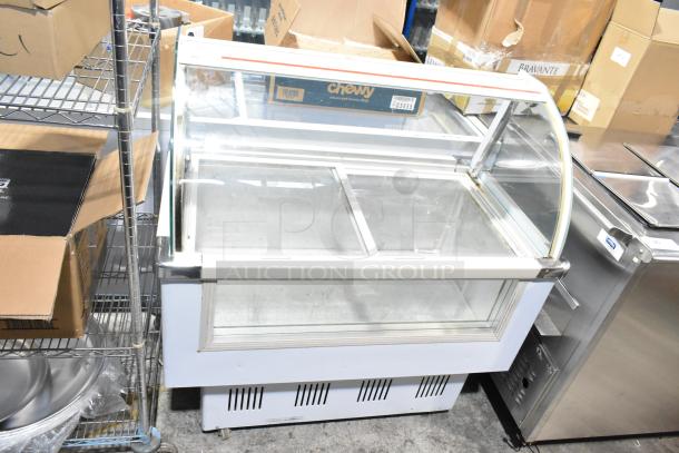 Commercial floor style deli display case merchandiser with glass front, used condition, visible storage shelves.