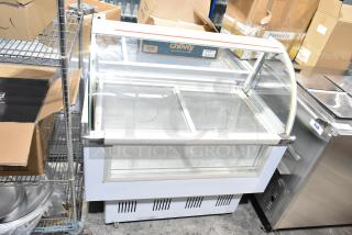 Commercial floor style deli display case merchandiser with glass front, used condition, visible storage shelves.