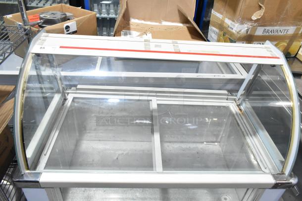 Commercial deli display case merchandiser, floor style, glass panels, white frame, some wear. Ideal for showcasing deli items.