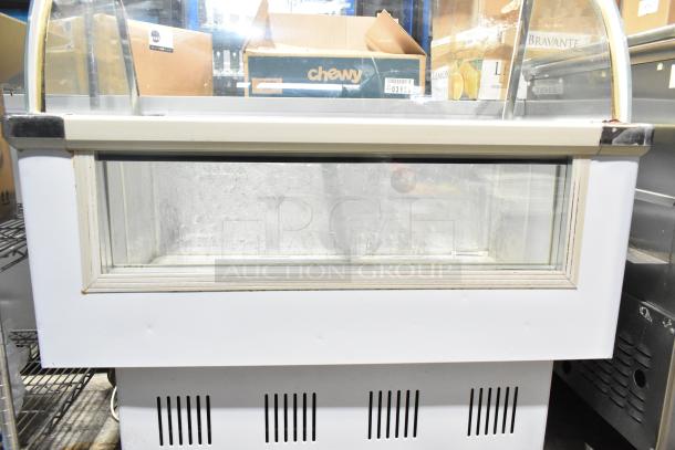 Commercial floor-style deli display case merchandiser, glass front, white frame, slight wear, spacious interior for product display.