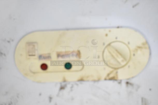 Close-up of control panel on commercial deli display case, showing dials and indicator lights, with visible wear.