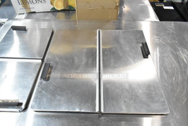 Commercial chest freezer with two center hinge lids and a sink bay, stainless steel exterior, in good condition.