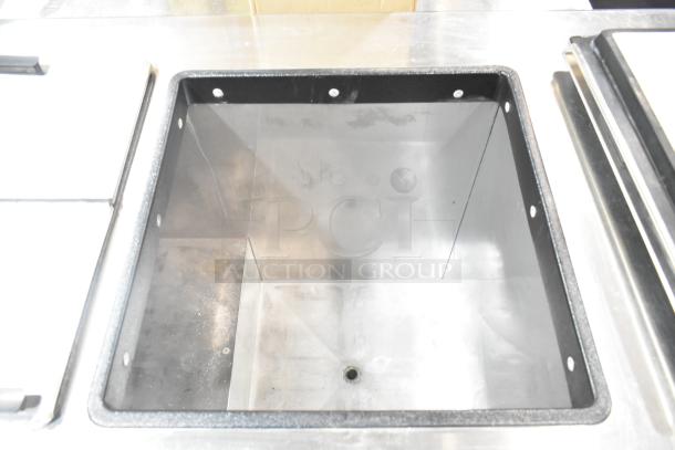 Commercial chest freezer with two center hinge lids and integrated sink bay, stainless steel, excellent condition.