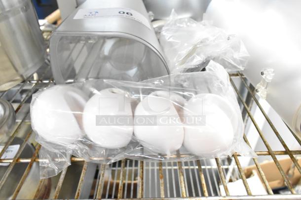 Two clear poly dry food dispenser hoppers on a metal shelf, each in new condition. Number tag visible on one hopper.