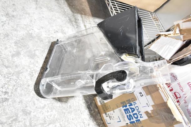 Lot of various items including clear plastic dry food dispenser hopper, in used condition, on a metal shelf.