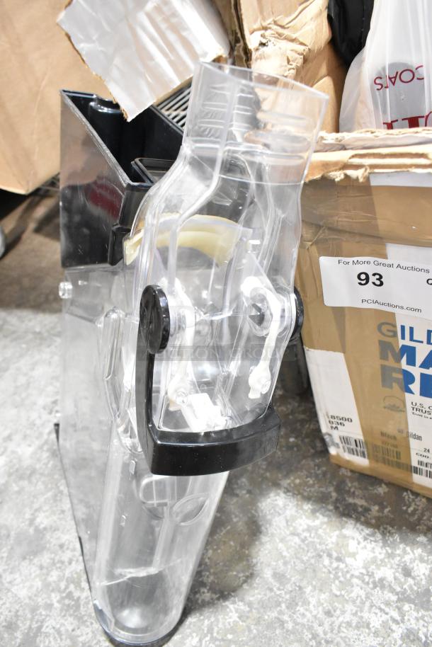 Clear plastic dry food dispenser hopper, black handle, next to a cardboard box. Slightly used condition. Auction label visible.