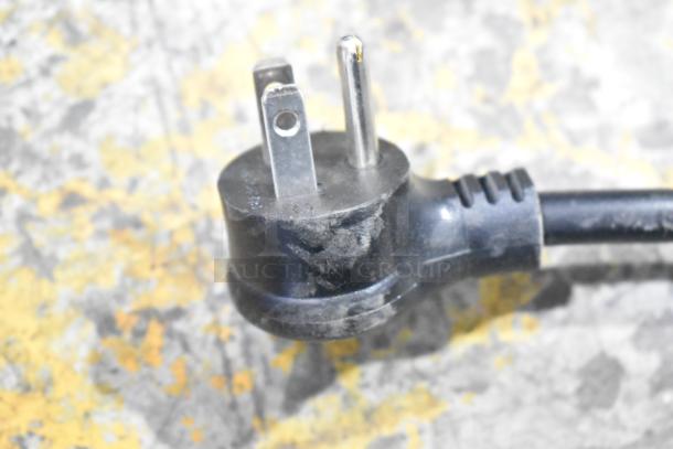 2021 True TSCI-600R-G-PH commercial cooler plug, 115 volts, 1 phase. Black three-prong plug, slight wear visible.