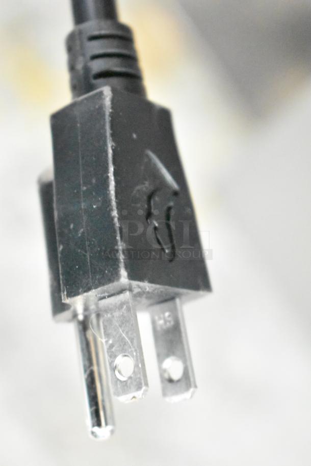 Close-up of a power plug for a Bunn ITCB-DV iced tea machine, 120 volts, 1 phase, showing standard prongs and slight wear.
