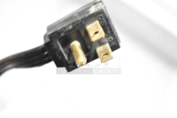Alt text: Blurred close-up of a three-pronged black plug connector, possibly part of a Master-Bilt BGR-15 cooler.