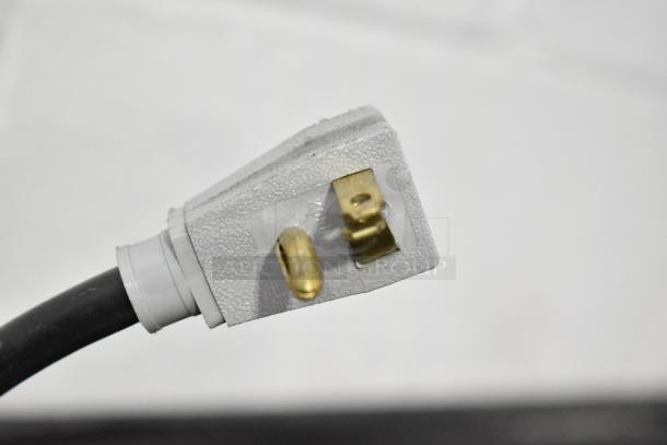 Close-up of a power plug for True GDM-41SL-54-LD Commercial Cooler, 115V, showing three-prong design and white textured casing.