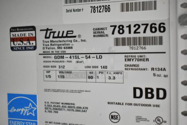 True GDM-41SL-54-LD Commercial Cooler label showing voltage 115V, phase 1, serial number 7812766, and NSF certification.