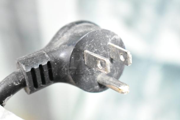 Black electrical plug of Crane 5800-4 vending machine, shown up close. Features 115 volts, 1 phase power.