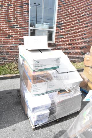 Pallet of 24 new scratch and dent items including boxes of napkins, guest towels, and food bags, wrapped in plastic.