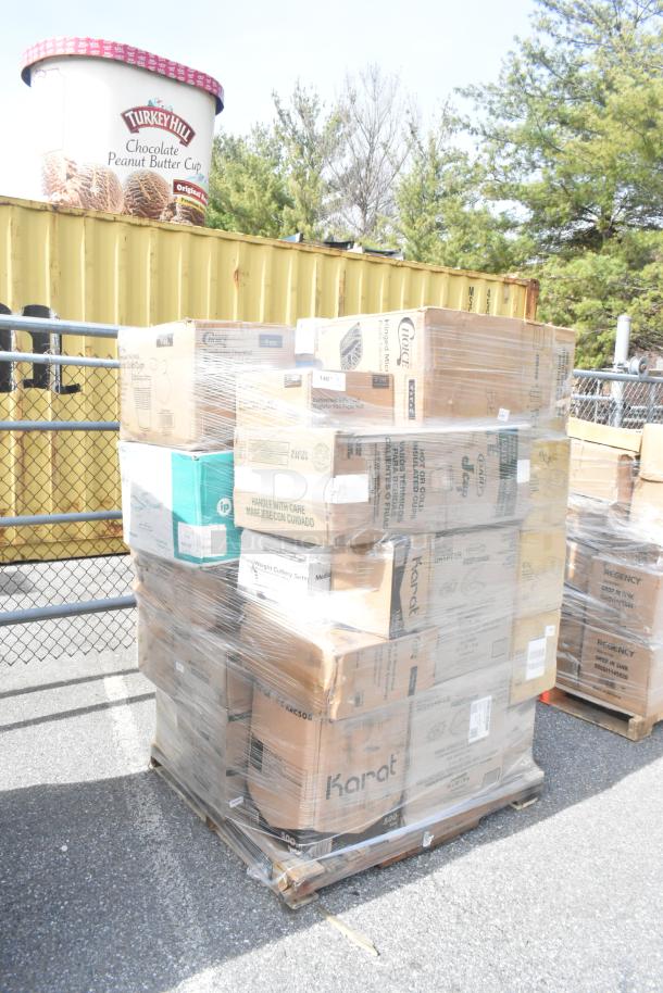 Stack of sealed cardboard boxes on a pallet containing assorted new scratch and dent items, including bags and foam cups.