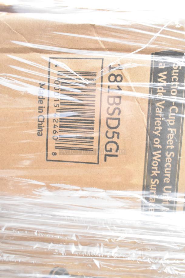 Box of 32 scratch and dent items, including salad spinner and glasses, wrapped in plastic. Barcode visible, labeled Made in China.