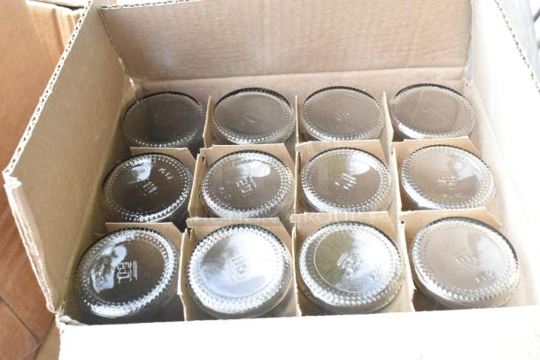 Box of glass jars with embossed markings in cardboard dividers. Part of a 40-item scratch and dent auction lot.