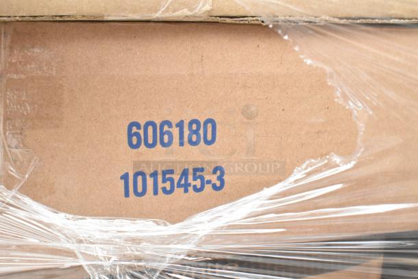 Cardboard box with visible serial numbers "606180" and "101545-3," wrapped in protective plastic. Part of scratch and dent auction.