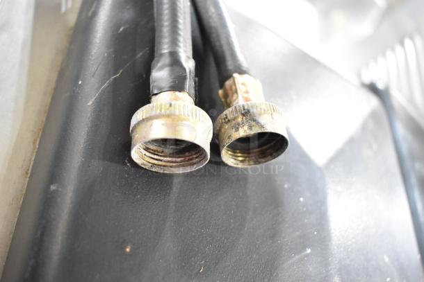 Close-up of metal hose connections on Electro Freeze SLX400E-137 ice cream machine. Connections show moderate wear.