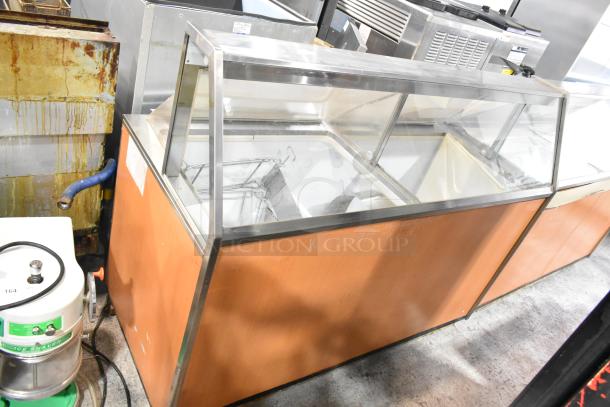 Commercial ice cream dipping cabinet with metal tub collars, 115 volts, 1 phase, wood exterior, good condition.